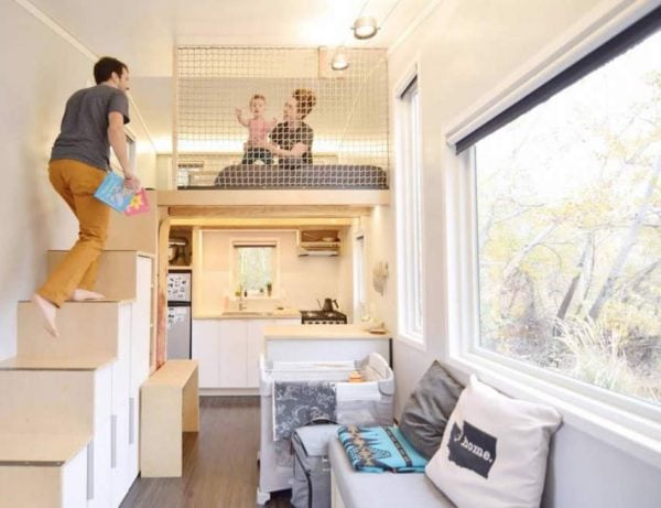 a couple playing with their baby on a loft bed