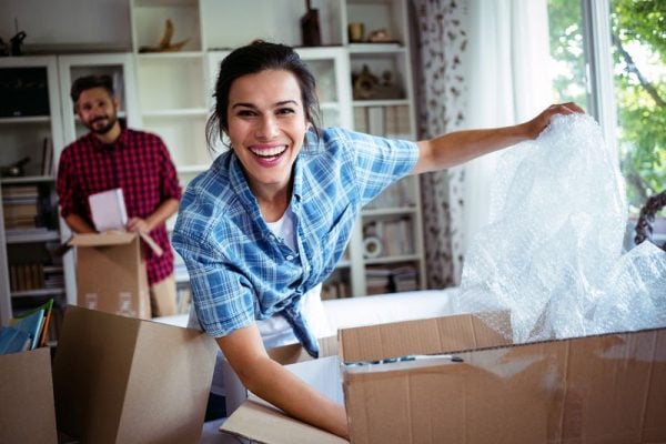 a happy couple unpacking boxes in their new home