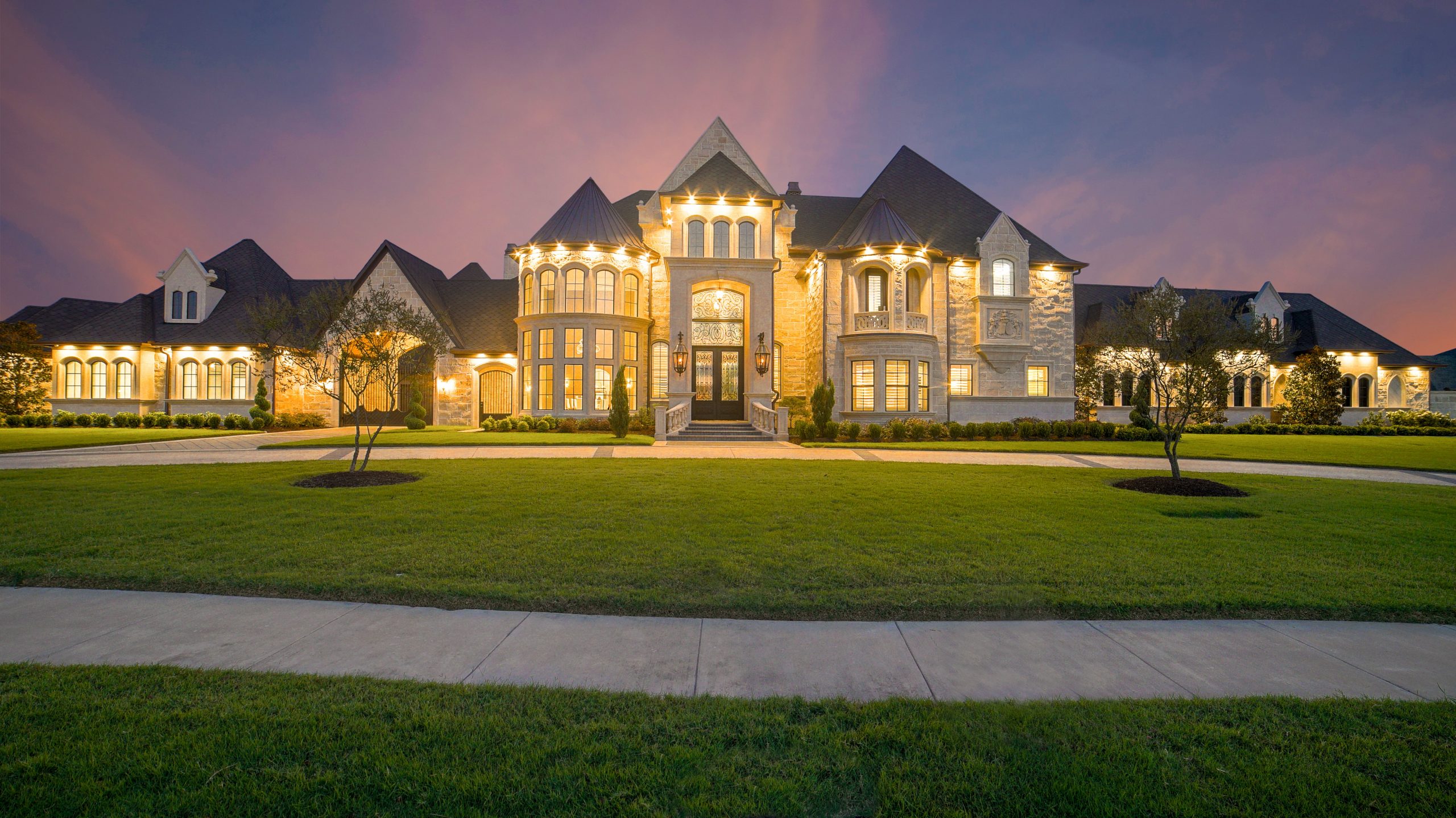 Big house with a big green grass area out the front and really nice lights